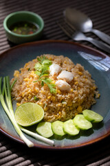 Crab meat fried rice on ceramic dish set on table.