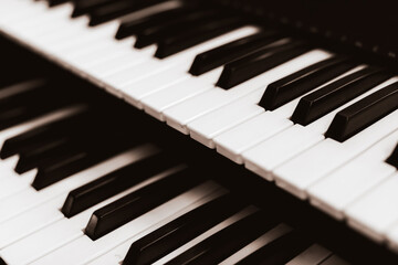 Naklejka premium Close focus on upper row of piano keyboard in black and white.