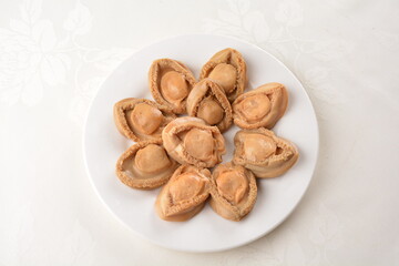 raw 10 head fresh abalone in slice and whole piece in white background asian seafood halal sashimi menu