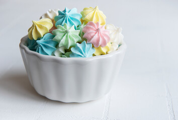 Small colorful meringues in the  ceramic bowl