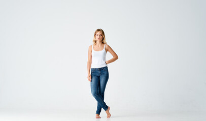 pretty woman in jeans posing fashion barefoot light background