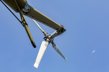 Powerful propeller and blades of a military helicopter against the background of a bright blue sky