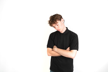 Obraz premium Sad guy looking down with his arms crossed portrait, white background, 18-20 years old. White european guy.