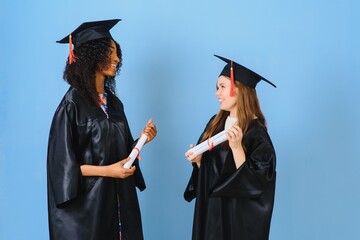 Two young women celebrating their graduation with diplomas