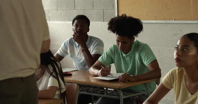 Diverse adolescent students in class listen to the teacher. School in Spain