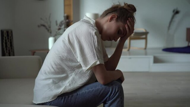 Sad woman sit alone feel depressed lonely. Upset single lady thinking of problem, suffer from melancholy loneliness