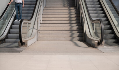 Man going down mechanical stairs in a station