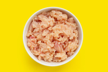 Minced meat of chicken fillet in white bowl on yellow background.