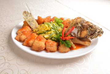 deep fried whole grouper fish seafood with sweet and sour sauce & mango salad in the middle asian halal menu