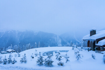 Winter landscape of a ski resort in the background of mountains after a heavy snowfall