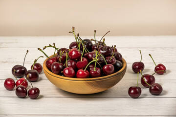 Bowl full of ripe red dark cherries on wooden table surface as Source of vitamins, organic food