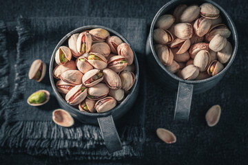 Brown pistachios on dark table. Quick and good snack.