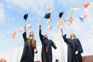 Students throwing graduation hats in the air celebrating