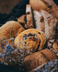 Different kinds of bread and baked goods, placed into box in vintage style decorated with dry flowers.