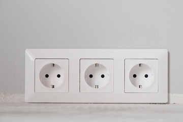 White electrical outlets with frame on gray wall background