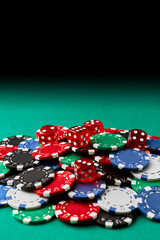 Pile of Casino pocker gambling chips and dices on green table