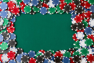 Pile of Casino pocker gambling chips on green table