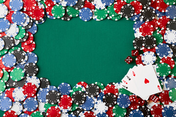 Casino chips, playing cards and dices on green fabric table
