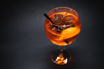 aperol spritz cocktail drink with orange and ice in glass on black background
