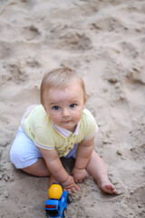 little boy playing in the sand. baby plays with sand. Summer rest. Sun, sea, beach, sand. Rest, childhood.