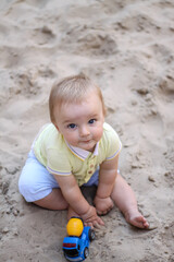 little boy playing in the sand. baby plays with sand. Summer rest. Sun, sea, beach, sand. Rest, childhood.