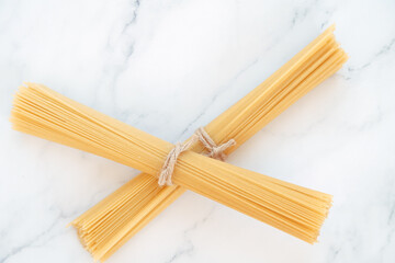two portions of uncooked spaghetti