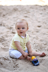 little boy playing in the sand. baby plays with sand. Summer rest. Sun, sea, beach, sand. Rest, childhood.