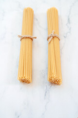 two portions of uncooked spaghetti