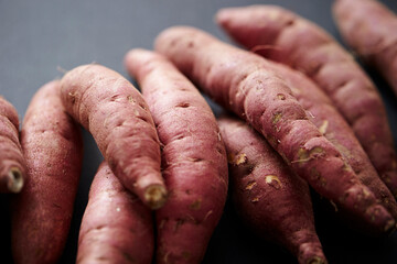 fresh sweet potato on black background