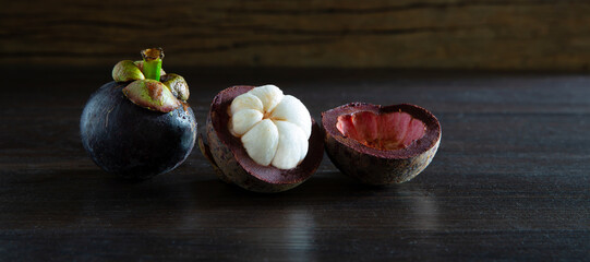 Fresh mangosteen Thai fruits on wooden table and old wooden wall