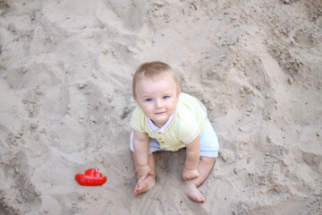 little boy playing in the sand. baby plays with sand. Summer rest. Sun, sea, beach, sand. Rest, childhood.
