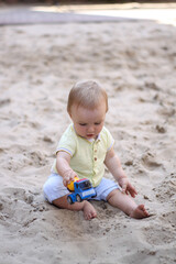 little boy playing in the sand. baby plays with sand. Summer rest. Sun, sea, beach, sand. Rest, childhood.