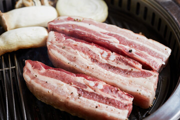 Raw pork belly on the grill