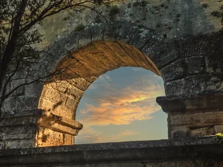 Papier Peint photo Pont du Gard Vue sur un coucher de soleil au travers d'une arche du pont du Gard