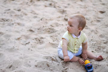 little boy playing in the sand. baby plays with sand. Summer rest. Sun, sea, beach, sand. Rest, childhood.