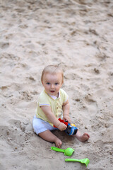 little boy playing in the sand. baby plays with sand. Summer rest. Sun, sea, beach, sand. Rest, childhood.