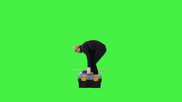 Professional handyman carry box of tools for renovation or fixing wear uniform young man repairman on a Green Screen, Chroma Key.