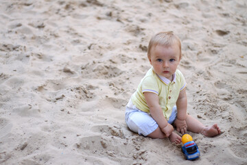little boy playing in the sand. baby plays with sand. Summer rest. Sun, sea, beach, sand. Rest, childhood.