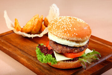 giant bake burger with bbq grill meat chicken chop wagyu beef steak, fried egg, French fries and vegetables on board western fast food menu