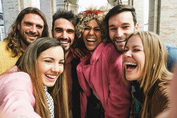 Happy multiracial friends having fun doing selfie together outdoor in city - Main focus on black girl face