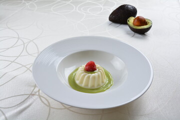 luxury chilled sweet coconut pudding jelly with avocado creamy sauce and raspberry fruit in plate and pink table cloth halal dessert menu