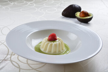 luxury chilled sweet coconut pudding jelly with avocado creamy sauce and raspberry fruit in plate and pink table cloth halal dessert menu