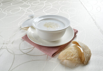luxury chilled sweet fresh bird nest soup with almond paste and peach resin in bowl and pink table cloth halal healthy dessert menu