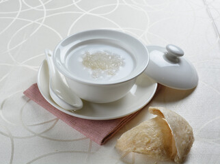 luxury chilled sweet fresh bird nest soup with almond paste and peach resin in bowl and pink table cloth halal healthy dessert menu