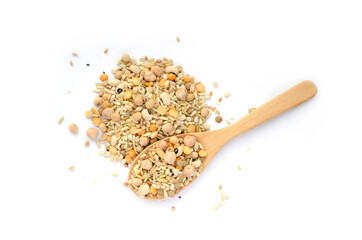 Mixed dry organic cereal and grain seed pile and wooden spoon in soft brown tone on white background