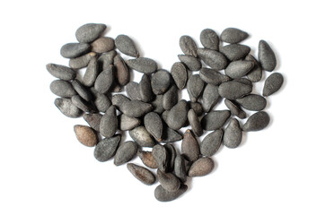 Closed up group of organic black sesame seed pile put together in heart shape on white background. For healthy or natural food ingredient lover concept