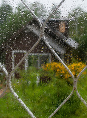 A July downpour. Drops of heavy rain on the window pane, macro