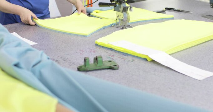 Electric cutter Fabric Machine. Cutting a fabrics in an workshop. Drapery Shop. Sewing, Tailoring and Clothes Making. Textile in textile factory.