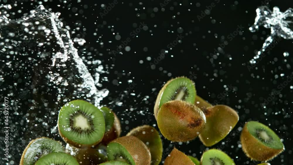 Poster super slow motion of sliced fresh kiwi with water splash flying in the air. filmed on high speed cin