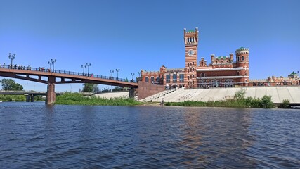 Bridge with a beautiful red tower and clock in the Republic of Meri El, in the city of Yoshkar-Ola in Russia. July 16, 2021